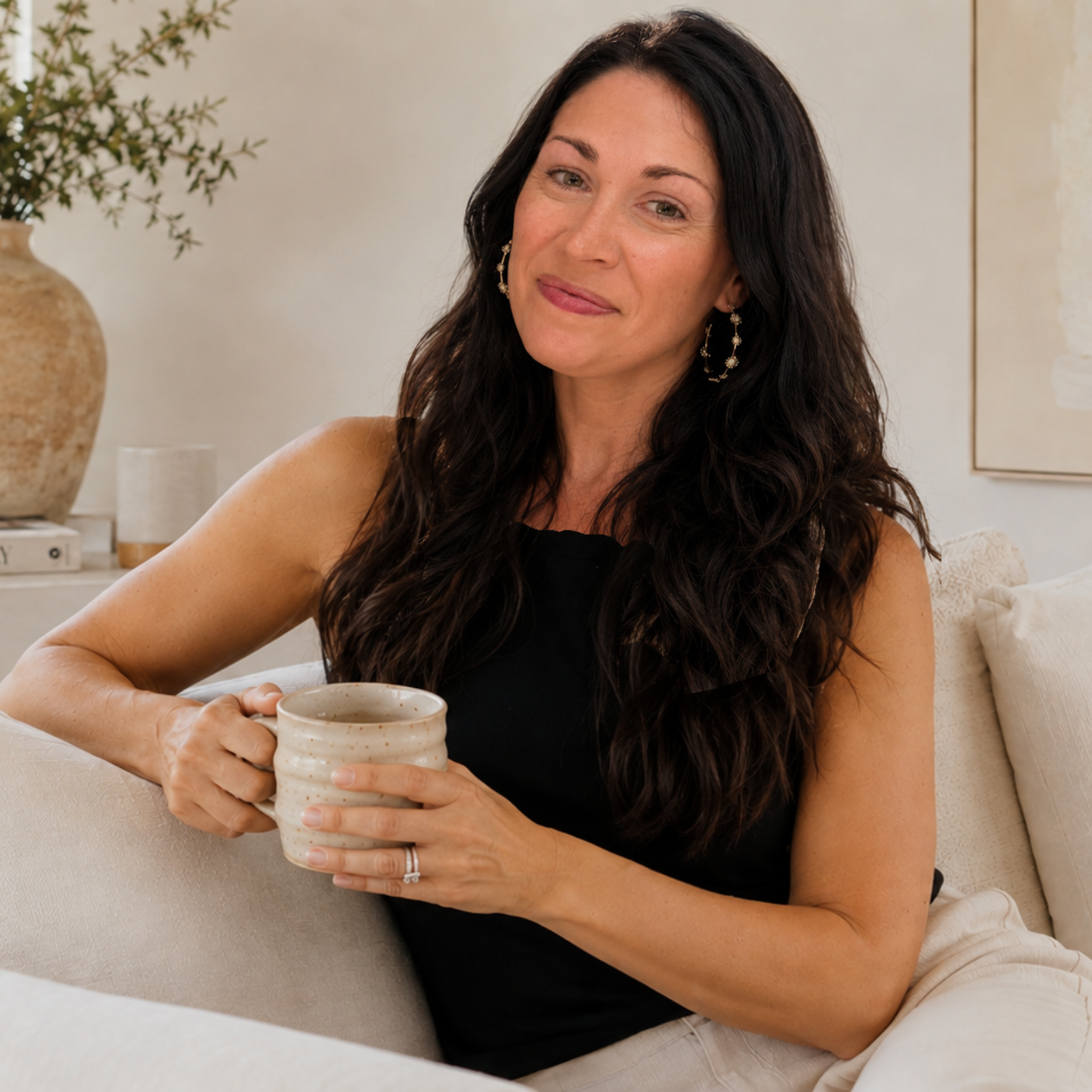 Kerri Kanter seated with a coffee mug in a softly lit interior